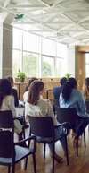 Personnes en réunion discutant de management interculturel et TDAH autour de documents colorés