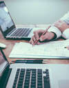 Deux personnes collaborent autour d une table en bois travaillant sur des documents et des ordinateurs pour illustrer les transformations du travail psychanalytique