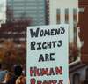 Cinq personnes souriantes dans une voiture décapotable illustrant le soutien et l'accompagnement des droits des femmes