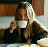 personne qui boit un café dans une tasse D'Accueil