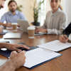 Homme signant document lors réunion collaboration professionnelle