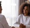 Femme médecin discute bienveillance avec adolescente cheveux bouclés