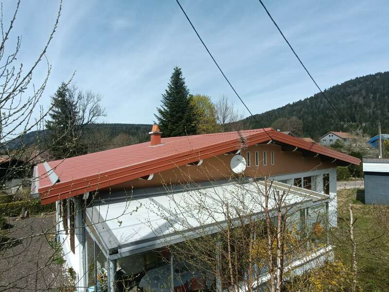 Maison à GERARDMER (88) – Rénovation de la couverture fibro-ciment en désamiantage, isolation extérieure ( sarking ) et couverture en panneaux tuiles