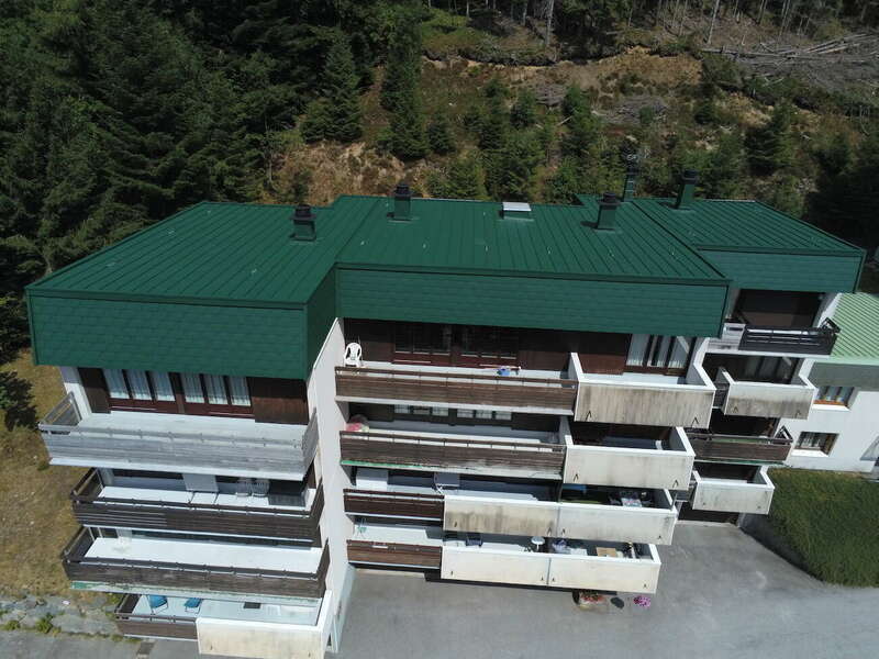 Copropriété à LA BRESSE (88) – Rénovation et isolation de la toiture, couverture en aluminium laqué à joint debout et bardage sur brisis en bardeaux aluminium laqué