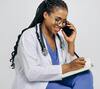 Accueil téléphonique IA pour médecin généraliste : médecin au téléphone prenant des notes