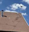 Drone pulvérisant traitement d'étanchéité de toiture