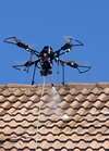 Drone survolant un bâtiment pour traitement de surface