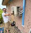 Technicien en génie climatique vérifiant une climatisation Fujitsu