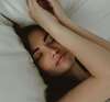 lit confortable avec personne endormie paisiblement sous une couverture douillette dans une chambre apaisante et bien éclairée par la lumière du matin, sommeil