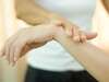 Kinésiologue effectuant un massage facial dans un environnement de bien-être pour harmoniser le tonus musculaire