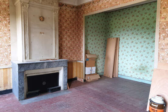 Une belle cheminée en marbre avec des tomettes anciennes au sol et une alcôve