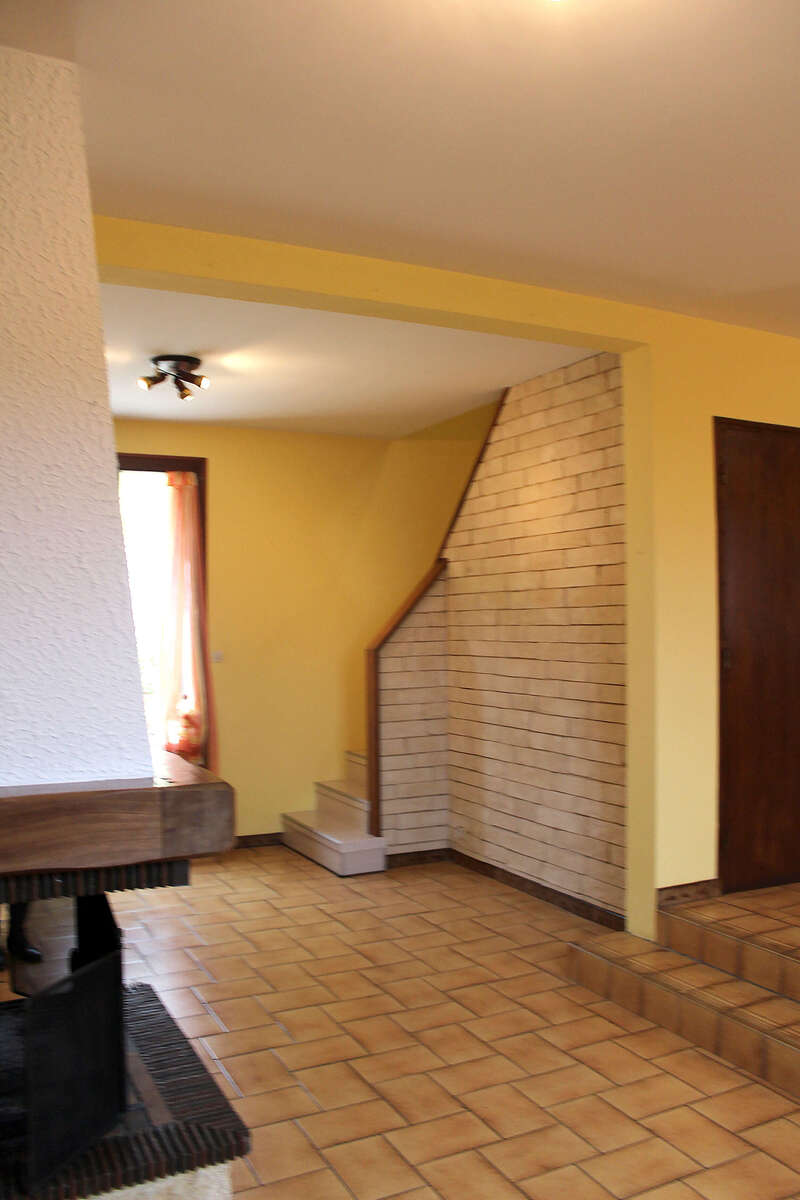 séjour année 70 avec cheminée imposante et carrelage marron