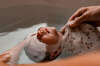 Bébé dans son bain tissu blanc motifs floraux