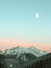 Paysage montagneux enneigé au crépuscule avec sapins et lune