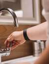 Personne réglant robinet lavabo en eau calcaire Normandie