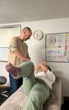 Kinésiologue manipulant jambe d'une patiente en séance de soin