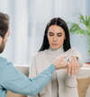 Un homme et une femme pratiquent un exercice de communication en PNL dans un intérieur avec plante verte