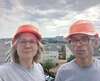 Deux professionnels casques sécurité orange devant paysage urbain écologique