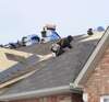 couvreurs qui changent des tuiles