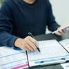 Personne structurant projet avec documents financiers et smartphone