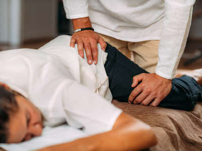 therapeute-etirant-la-jambe-de-la-femme-massage-shiatsu