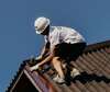 Homme effectuant travaux toiture pliage couvertines aluminium