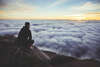 homme assis sur une montagne regardant le ciel