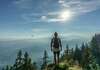 sportif en haut d'une montagne regardant le ciel et le massif