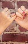pinky promise sur fond de briques rouges