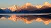 Montagnes enneigées reflétées dans un lac calme au lever du soleil