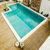 terrasse en bois entourant une piscine