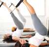personnes pratiquant pilates reformer avec coach