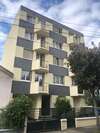 Façade d’un immeuble avec balcons et enduit clair