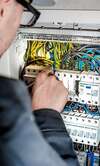 électricien travaillant sur un tableau électrique moderne