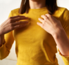 Femme en pull jaune pratique EFT sur sa poitrine