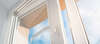 fenêtre PVC blanche entrebâillée avec ciel bleu lumineux