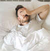 Homme dans lit blanc sous couverture symbolisant accompagnement nocturne