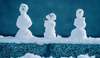trois bonshommes de neige miniatures sur neige sombre