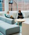 Deux femmes discutent gestion administrative dans salon moderne
