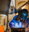 Homme fabriquant châssis mécano-soudé dans un atelier