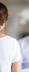Femme de dos en t-shirt blanc, cheveux relevés