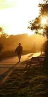 Femme marchant sur chemin vers le soleil 