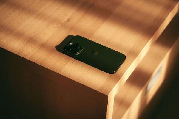 Un téléphone posé à l’envers sur une table dans la lumière du matin, illustrant le doute face à une infidélité émotionnelle