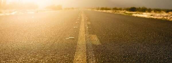 Une route qui s’étire vers la lumière du matin, illustrant le chemin et le temps qu’il faut pour pardonner une infidélité