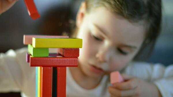 enfant concentré qui fait une construction