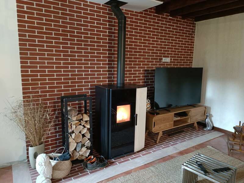 rénovation cheminée poêle à bois mur briques rouges mur blanc meuble TV bois 