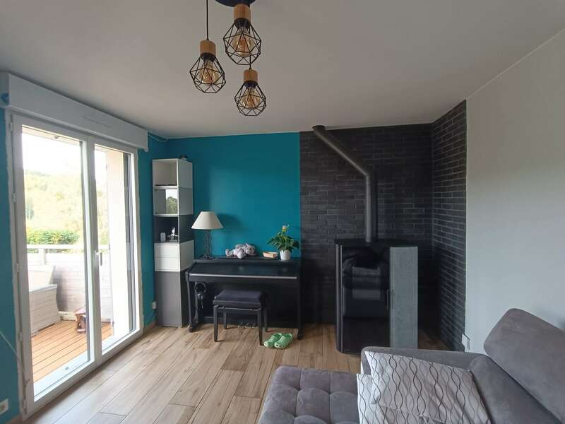 rénovation cheminée poêle à bois noir mur briques noires mur bleu