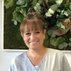 Portrait de Carine souriante avec fond neutre
