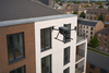 Drone en vol rapproché effectuant une inspection technique de la façade d’un immeuble moderne en ville, usage professionnel et réglementé C5
