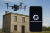 Drone scannant un bâtiment en pierre avec l’application RealityScan affichée sur smartphone